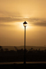 setting sun illuminating old lamp post