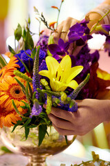 Fototapeta na wymiar Bouquet of beauty. Closeup shot of a florists hands arranging a colourful bouqet.