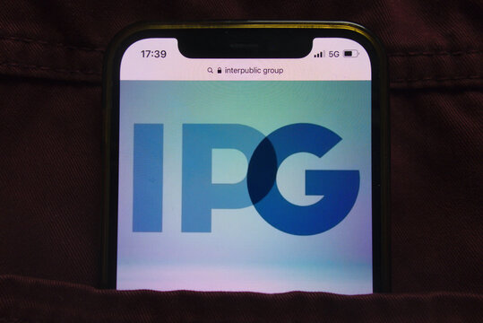 KONSKIE, POLAND - February 27, 2022: Interpublic Group of Companies IPG logo on mobile phone hidden in jeans pocket
