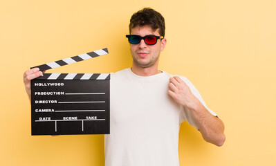 young handsome man looking arrogant, successful, positive and proud. cinema clapper concept