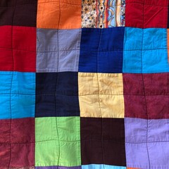 Nahaufnahme von Quadraten einer bunten Quiltdecke 