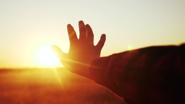 hand reaches for the sun. religion life freedom concept. girl pulls her hand to the sun at sunset close-up nature lifestyle energy. religion work on oneself concept