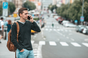 Young caucasian man smiling happy using smartphone outdoors
