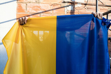 Woman holds her Ukrainian flag to claim no to war.  
