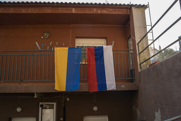 Flags of Russia and Ukraine draped on a house in Russia. No war. Copy space. 