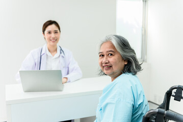 Obraz premium Asian elderly woman, Looking and smile with blurred soft of female doctor background, to annual health check of the elderly concept.