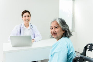 Asian elderly woman, Looking and smile with blurred soft of female doctor background, to annual health check of the elderly concept.