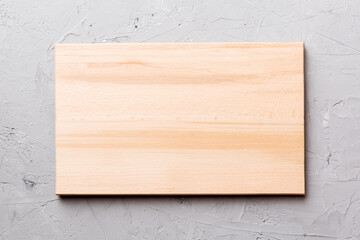 Top view of wooden cutting board on cement background. Empty space for your design