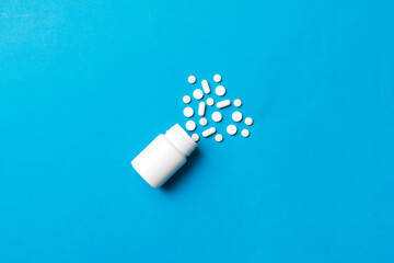 Multicolored pills and capsules in plastic bottle on Colored background, copy space. Many different...