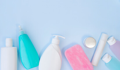 Bottles and jars with cosmetics on a light blue background