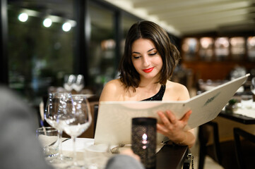 Woman reading the menu at the restaurant