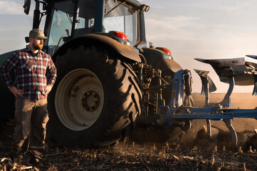 Young farmer working during the tractor plowing fields
