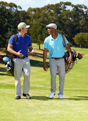 Discussing the handicaps. Shot of two friends talkin on their way to the tee-off.