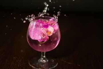в прозрачном бокале брызги от падающих в воду предметов