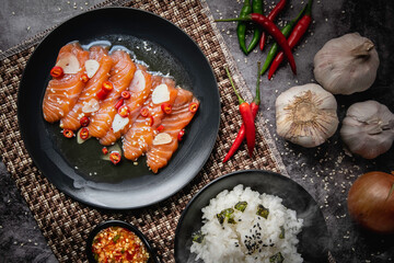 Salmon in fish sauce, Japanese style food, popular with Thai people nowadays. Red meat on a black...