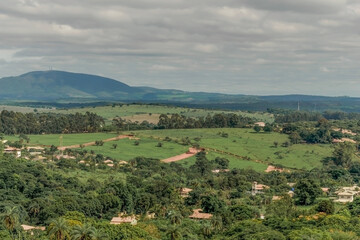 Fototapeta na wymiar Linda área de sítios, com muitas matas em volta, montanhas ao longe e belas construções na região de Igarapé, Minas Gerais