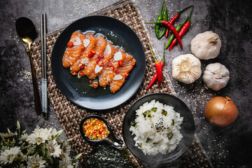 Salmon in fish sauce, Japanese style food, popular with Thai people nowadays. Red meat on a black plate