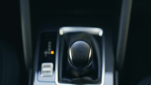 Female hand using a car automatic gear. Woman driving concept