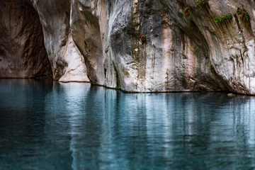 Poster clear blue water in a deep canyon with sheer rock walls © Evgeny