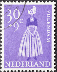 Netherlands - circa 1958: a postage stamp from the Netherlands, showing a woman in the traditional...