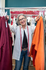 Woman standing between racks with colorful clothes