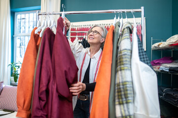 Woman touching hanger with dress looking up