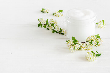 Obraz na płótnie Canvas Herbal facial cream cosmetic for skin care with white flowers