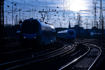 Trains arriving at Dortmund station blue hour evening twilight. Curved main line railway tracks...