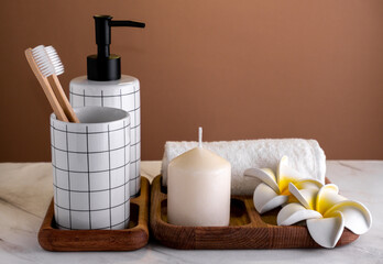 Obraz na płótnie Canvas Toiletries composition on marble table against brown wall. Spa concept.