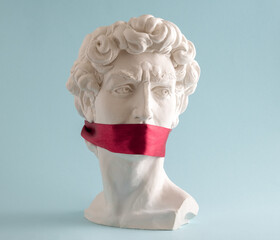 Statue of  David  head  with red ribbon on mouth on  blue background. Minimal art poster.