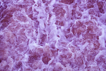 Unfocused abstract background . Colorful foam with bubbles in the water. The texture of the foam is purple.