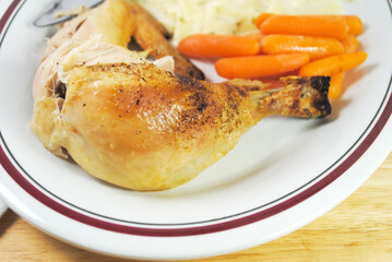Close Up of a Roasted Chicken Leg Serve on a Plate with Other Healthy Foods