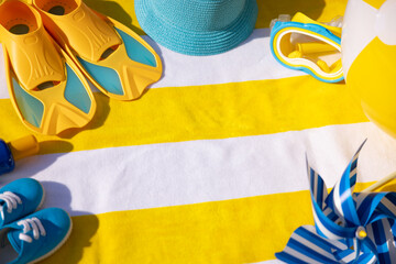 Beach accessories on yellow striped towel