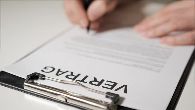 Contract in German. The hands of man or woman sign paper copy of the agreement. Universal form of contract in German-speaking countries.