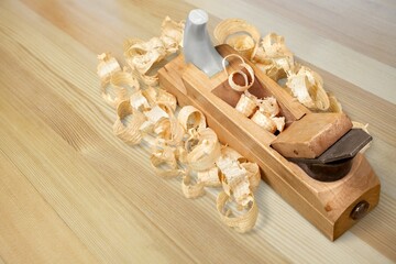 Plane jointer carpenter or joiner tool and wood shavings. Wood working tools on wooden table. Carpentry workshop