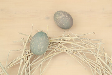 Easter eggs with a beautiful eco-friendly pattern lying in a decorative nest of white rods