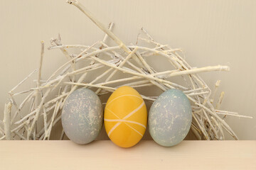 Easter eggs with a beautiful eco-friendly pattern lying in a decorative nest of white rods