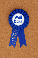 Well done message on blue winner ribbon on a bulletin board