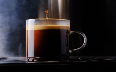 glass cup of espresso hot coffee with water coffee drop on dark background