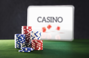 Gambling on internet casino. Online betting with tablet, computer or laptop. Stack of poker chips...