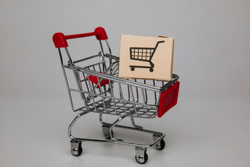 Shipping boxes in shopping cart trolley close-up, shopping and commerce concept