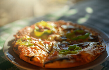 Crispy hot pizza with ham and green paprika.