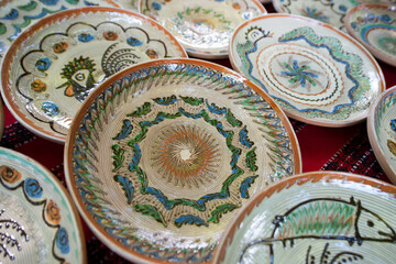 Traditional ceramic hand painted plates exposed on a table in Horezu, Valcea, Romania.
