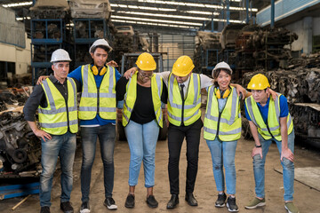 happy young factory worker with colleagues. Group of happy workers in uniform at factory.