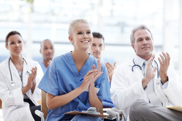 Fototapeta premium Celebrating breakthroughs in healthcare. Doctors and nurses applauding their lecturer.