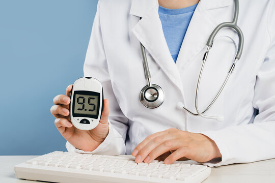 Mid-section Of A Female Doctor Showing Blood Suger Level Tester. Diabetes, Glucose Level 9.5