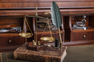 Scales of justice with law books on table of notary public in office.