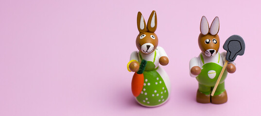 Two easter bunnies on a pink background with copyspace