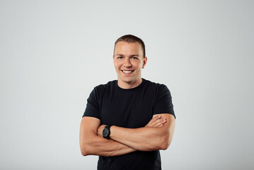 Portrait of attractive young man in black t-shirt looking into the camera .White background