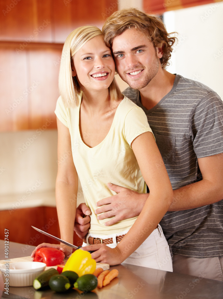 Wall mural Kitchen romance. Portrait of a happy young couple standing in the kitchen.